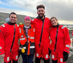 Four people in red immersion suits