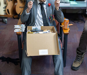 An expeditioner holding pre-made "Mawson Bucks" dollars for betting during Two-up.