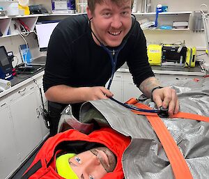 A person inspecting the dummy in a medical clinic