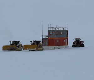 a small building and three large pieces of plant equipment on the ice