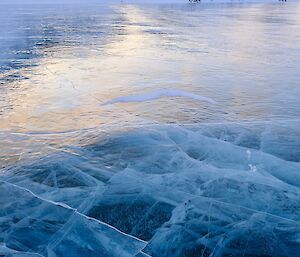 picture of dark blue-clear ice floor with deep cracks visible