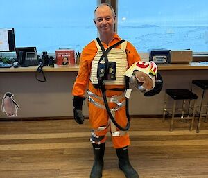 A man is dressed in orange overalls and accoutrements to look like an X-Wing Fighter Pilot from Star Wars