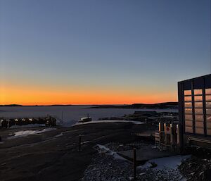 Balloon building to the right, overlooking a blood-orange sunset into the distance with clear skies
