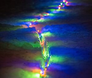 A row of colourful lights wedged into the ice