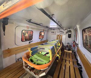 A ladder is tied to a stretcher, propped inside the back cab of the station's Search and Rescue Haggland over-snow vehicle