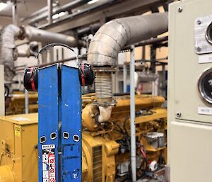 A blue ladder inside the station's powerhouse, with large yellow generators in the background