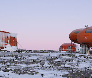 A photo of a number of orange field huts located at Bechervaise Island.