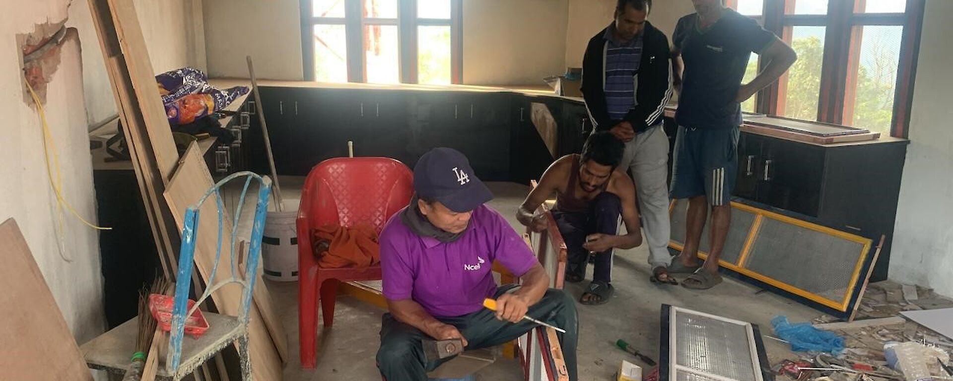 A group of men are working in a room with construction materials lying around in Nepal