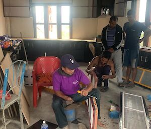 A group of men are working in a room with construction materials lying around in Nepal