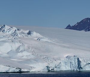 A panoramic photo of the rugged David Range in the background, with ice cliffs and cravassed-snow in the foreground
