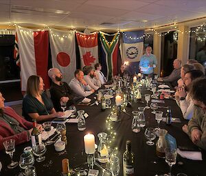 Expeditioners at the table listening to the midwinter speech.