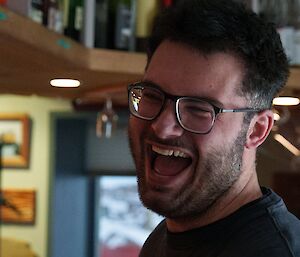 An expeditioner laughing at the bar.