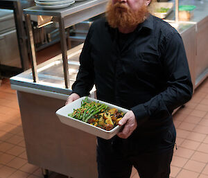 Expeditioner carrying food dishes from Kitchen - to be placed on the dinner table upstairs