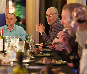 Expeditioners sitting at the dining table, enjoying food and drink.