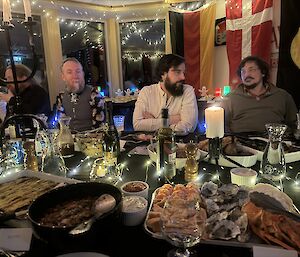 Expeditioners sitting at the dining table, surrounded by plates of food and decorations.