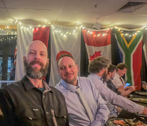 Two expeditioners posing for a photo at the dinner table.