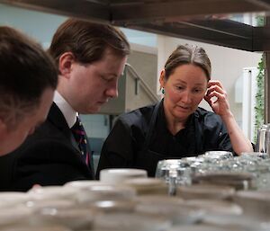 Chef Jordan giving instructions to a couple of expeditioners on food preparation and delivery from kitchen to dining room.