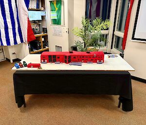 A cake made in the shape and colour of Casey's Red Shet sitting on a table.