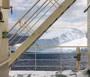 A picture of the deck of the Nuyina, with icebergs floating in the sea in the background.