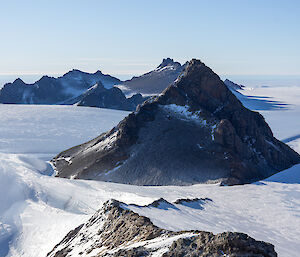 A picture of jagged mountain ranges dispersed on an icy landscape.