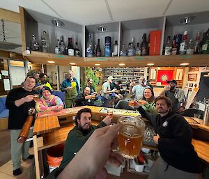 Expeditioners gathered in Mawson's bar, celebrating finish of the swim with hot-buttered rum drinks