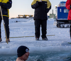 An expeditioner in the sea ice swimming hole, coming to terms with the very cold water
