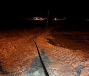 A fuel line light in the snow with light in the distance