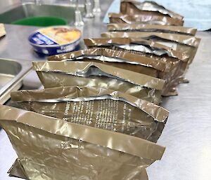 A stack of dehydrated meals on a kitchen bench
