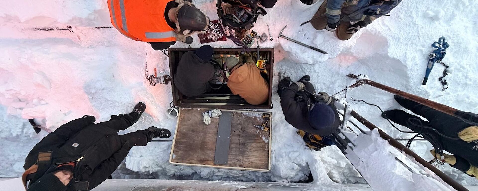 Aerial view, looking down on the fuel pump team, standing in the ice.