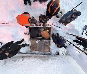 Aerial view, looking down on the fuel pump team, standing in the ice.