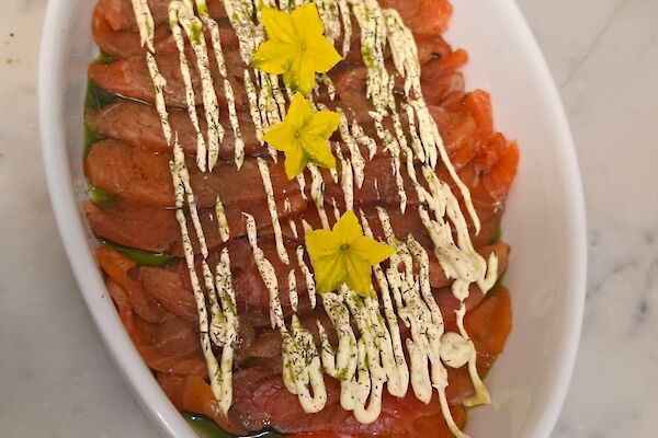 smoked salmon in a white bowl on a bench