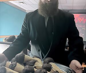 An expeditioner presents a tray of choc tops