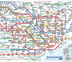A document page showing a maze of colourful lines in red, orange, yellow, lime, green, jade, aqua, blue, indigo, violet. Numbers and symbols associated with train stations and train travel also cover the page.