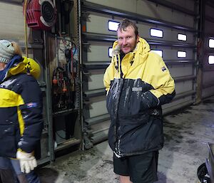 A man in a shed wearing shots