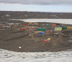 An aerial view of a group of colourful buildings in a rocky brown landscape