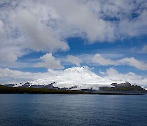 A snow covered volcano rising out of the sea