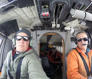Two people in the pilot and co-pilot's seat on a plane