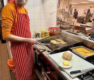An expeditioner standing next to a hotplate in the kitchen, cooking French toast