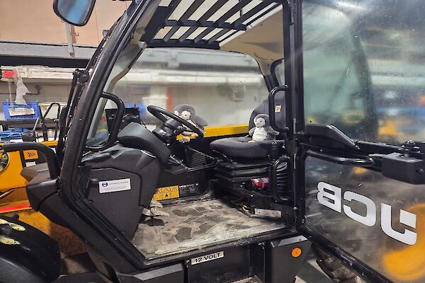 A toy penguin sitting in an all-terrain vehicle