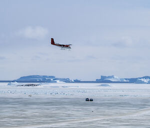 A red and white plane comes in to land on an sea ice runway