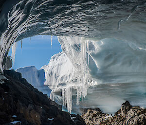 Looking out of an ice cave with icicles hanging down