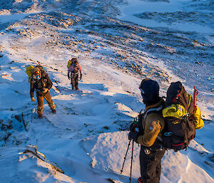 Expeditioners stand on a snowy ridge