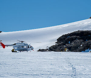 A helicopter lands in a snowy landscape