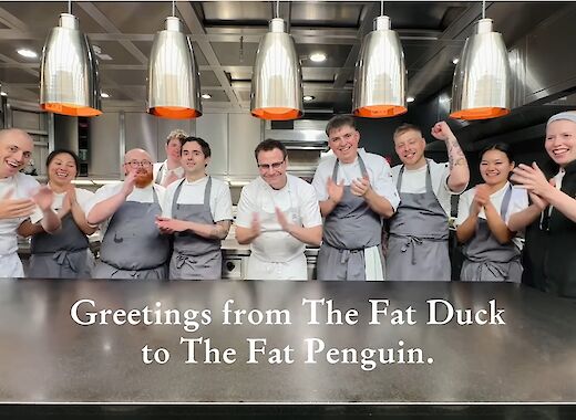 The kitchen of famous restaurant 'The Fat Duc', with 10 staff members standing, clapping and cheering.
