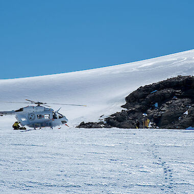 A helicopter lands on the snow