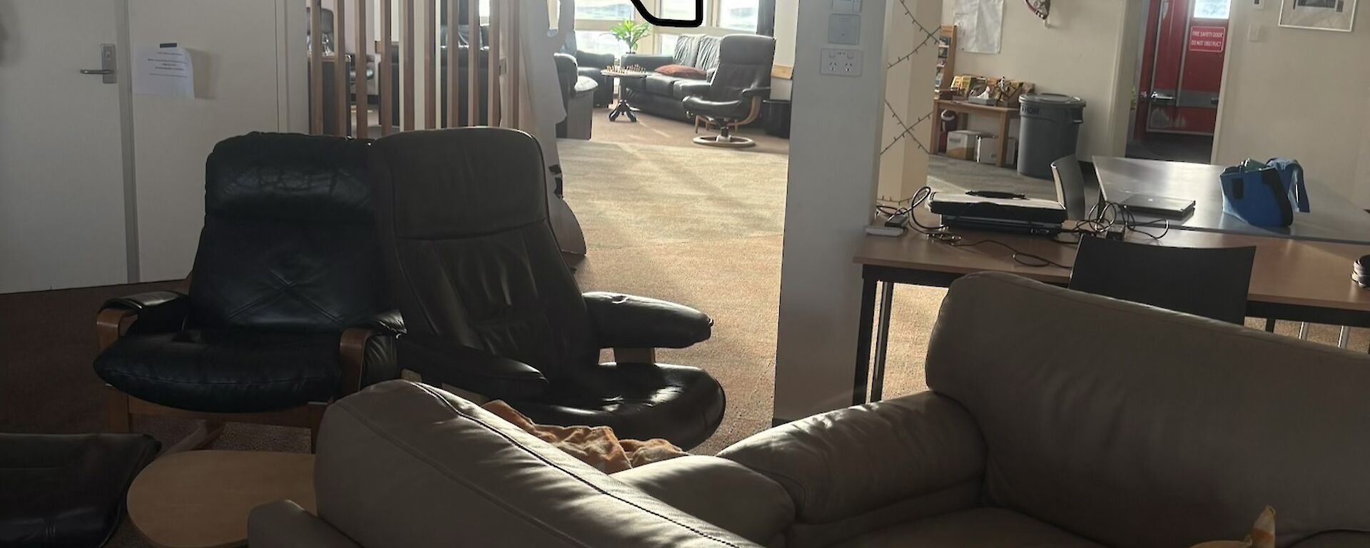 Two brown leather chairs put together to make a couch