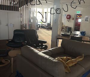 Two brown leather chairs put together to make a couch