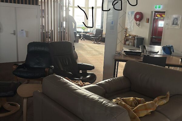 Two brown leather chairs put together to make a couch