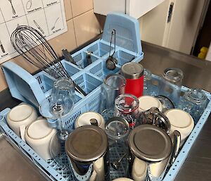 A dishwasher rack stacked with cups