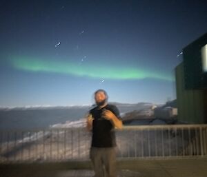 A blurry picture of a person with aurora slightly visible in the sky